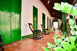 una fila de sillas sentadas en una habitación con paredes verdes en HOSTAL LA MOMPOSINA, en Mompox