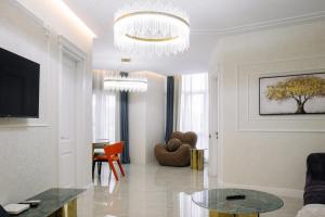 a living room with a table and a chandelier at Luxurious Mamu Apartment in Batumi