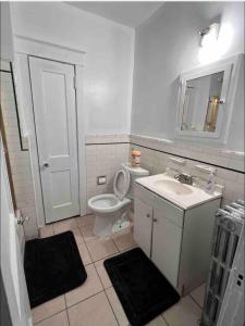 a white bathroom with a toilet and a sink at Private Room #3 in Philadelphia