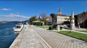 a boat is docked on a sidewalk next to the water at Carla Apartment Opuzen Modern Oasis and Comfort in Opuzen