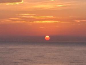 a sunset over the ocean with the sun in the sky at Attico fronte mare in Martinsicuro