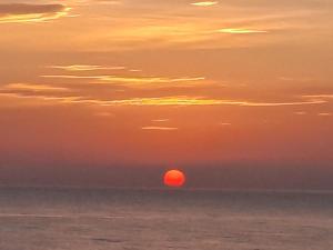 a sunset over the ocean with the sun in the sky at Attico fronte mare in Martinsicuro