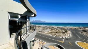 a balcony of a building with a view of the ocean at Oceansnest Guest House in Bloubergstrand