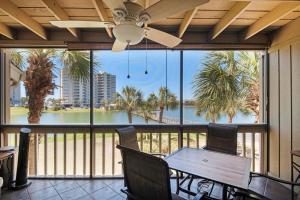 een patio met een tafel en stoelen en een groot raam bij Seascape Lakefront Villas 281- Family Tides in Destin