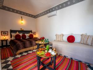 een woonkamer met 2 bedden en een tafel bij Riad dar dada&spa in Marrakesh