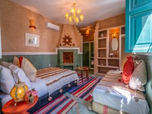 een slaapkamer met 2 bedden en een open haard bij Riad dar dada&spa in Marrakesh