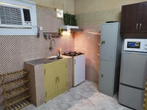 a small kitchen with a sink and a refrigerator at منزل صحم in Al Quşayr