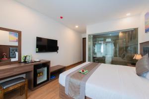 芽莊的住宿－Marilla Nha Trang Hotel - by Bay Luxury，卧室配有一张白色大床和电视。
