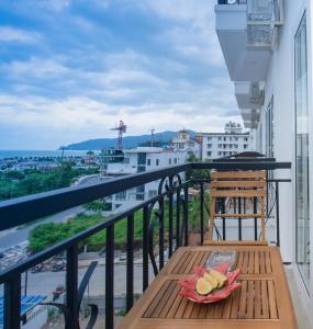 芽莊的住宿－Marilla Nha Trang Hotel - by Bay Luxury，阳台配有一张木桌,上面有一盘水果