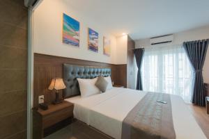 芽莊的住宿－Marilla Nha Trang Hotel - by Bay Luxury，一间卧室设有一张大床和玻璃淋浴间