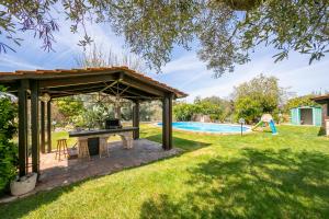 stół piknikowy pod pawilonem obok basenu w obiekcie La Casa Sulla Roccia Trulli Pool - Happy Rentals w mieście Monopoli