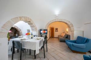 jadalnia ze stołem i krzesłami oraz salon w obiekcie La Casa Sulla Roccia Trulli Pool - Happy Rentals w mieście Monopoli
