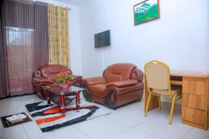 a living room with a chair and a desk at Western Mountain Hotel in Rubavu