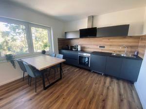 een keuken met een houten tafel en een houten vloer bij Montihaus Gäste & Monteurzimmer in Dormagen