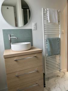 uma casa de banho com um lavatório e um espelho em La Dunette, appt cozy à 150 m de la plage em Merlimont