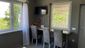 a dining room with a table and two windows at Ležimirski Snovi in Ležimir