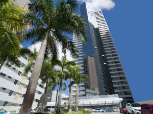 um grupo de palmeiras em frente a edifícios altos em Betel Flat Executive Praia Boa Viagem no Recife