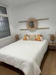 a bedroom with a large white bed with a mirror on the wall at AT Osario 12 con Parking in Córdoba