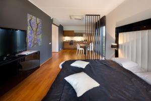 a bedroom with a large bed and a kitchen at GMP Clubhotel Apartments in Otepää +72 photos