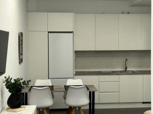 a kitchen with white cabinets and a table and chairs at AT Osario 12 con Parking in Córdoba