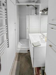 baño blanco con ducha y lavamanos en Appartement Lumineux à Thorigny, en Thorigny-sur-Marne