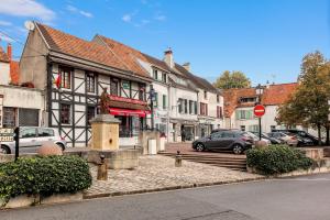 a city street with cars parked in front of a building at Appartement Lumineux à Thorigny in Thorigny-sur-Marne