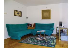 ein Wohnzimmer mit einem blauen Sofa und einem Tisch in der Unterkunft House Fortin With Sauna Near Bloke Lake in Velike Bloke
