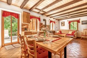 Il comprend une cuisine et une salle à manger avec une table en bois. dans l'établissement House By The Stream, à Avče