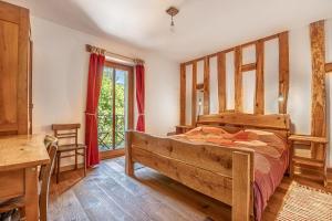 - une chambre avec un lit en bois et une fenêtre dans l'établissement House By The Stream, à Avče