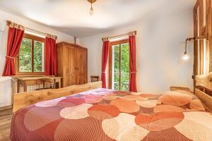- une chambre avec un grand lit et des rideaux rouges dans l'établissement House By The Stream, à Avče