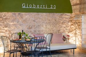 un tavolo con sedie e un divano di fronte a un muro di Giob Studio In The Centre - Happy Rentals a Martina Franca