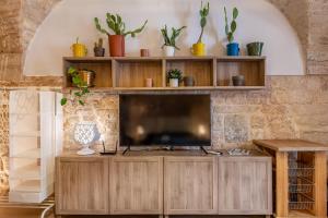 un soggiorno con TV e scaffali in legno di Giob Studio In The Centre - Happy Rentals a Martina Franca
