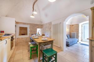 cocina y sala de estar con mesa y sillas en Trullo Fedele Grande125 - Happy Rentals, en Ceglie Messapica