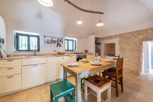 cocina grande con mesa de madera y sillas en Trullo Fedele Grande125 - Happy Rentals, en Ceglie Messapica