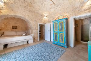 1 dormitorio con cama y alfombra azul en Trullo Fedele Grande125 - Happy Rentals, en Ceglie Messapica