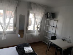 una habitación con una cama y una mesa y una ventana en Tout à pied - 2 pers - 2 studios indépendants B et C, en Berck-sur-Mer