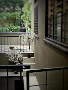 a balcony with two potted plants and a window at 85 Boutique Hotel in Ipoh