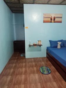 1 dormitorio con 1 cama y suelo de madera en Weeroona Huts Homestay Pacifico, en San Isidro