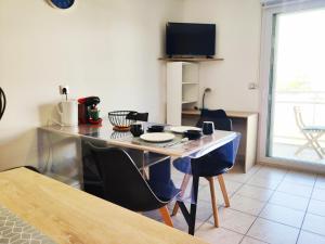 - une cuisine avec une table et des chaises dans la chambre dans l'établissement Joli appartement aux Minimes avec Parking, à La Rochelle