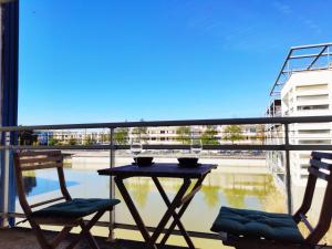 d'une table et de deux chaises sur un balcon avec vue. dans l'établissement Joli appartement aux Minimes avec Parking, à La Rochelle