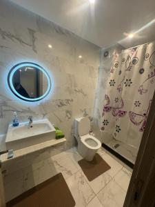 een badkamer met een toilet, een wastafel en een spiegel bij Appart haut standing coralia 14 in Oujda