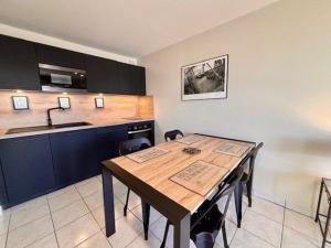 a kitchen with a wooden table and a sink at Appartement Quiberon, 2 pièces, 4 personnes - FR-1-478-78 in Quiberon