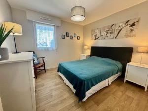 Schlafzimmer mit einem Bett mit grüner Tagesdecke in der Unterkunft Appartement Quiberon, 2 pièces, 4 personnes - FR-1-478-78 in Quiberon