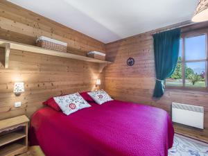 a bedroom with a red bed with wooden walls at Appartement Megève, 3 pièces, 4 personnes - FR-1-453-275 in Megève