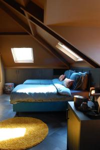 een slaapkamer met een bed in een kamer met een zolder bij Boutique Hotel de Bungelaer in Beers