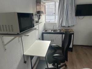 Urban Fourways Haven في Sandton: مطبخ صغير مع مكتب وميكروويف