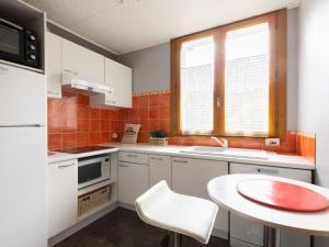 uma cozinha com armários brancos e uma mesa branca em Appartement Saint-Lary-Soulan, 4 pièces, 6 personnes - FR-1-296-310 em Saint-Lary-Soulan