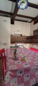 eine Küche mit einem Tisch und einem rosa Tischtuch in der Unterkunft La Casina sul Fiume in SantʼAgata