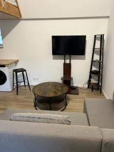 - un salon avec une table basse et une télévision à écran plat dans l'établissement Grand Place Roubaix Appartement Style Loft, à Roubaix