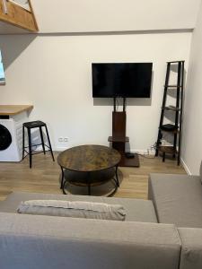 a living room with a coffee table and a flat screen tv at Grand Place Roubaix Appartement Style Loft in Roubaix
